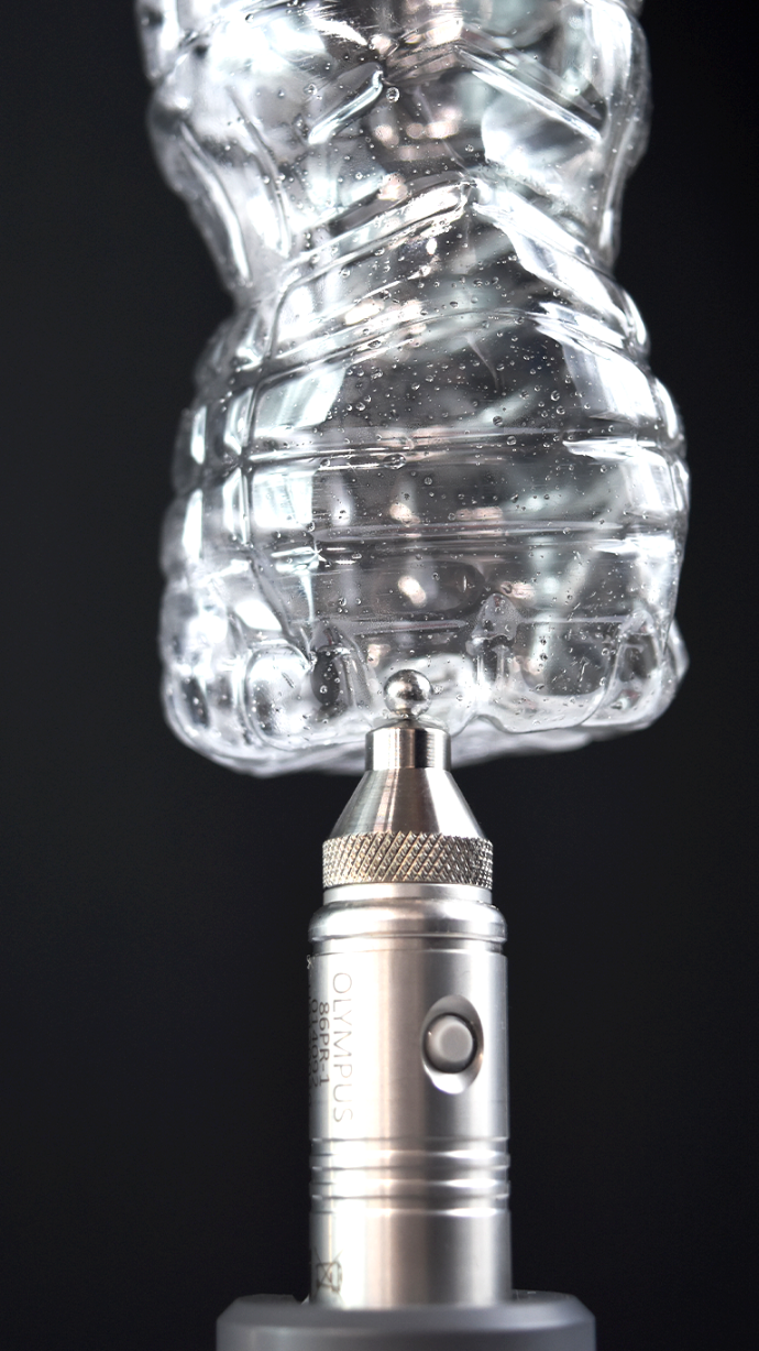 Sonda Evident del equipo Magna-Mike realizando medición de espesor en una botella de plástico PET transparente mediante efecto Hall.